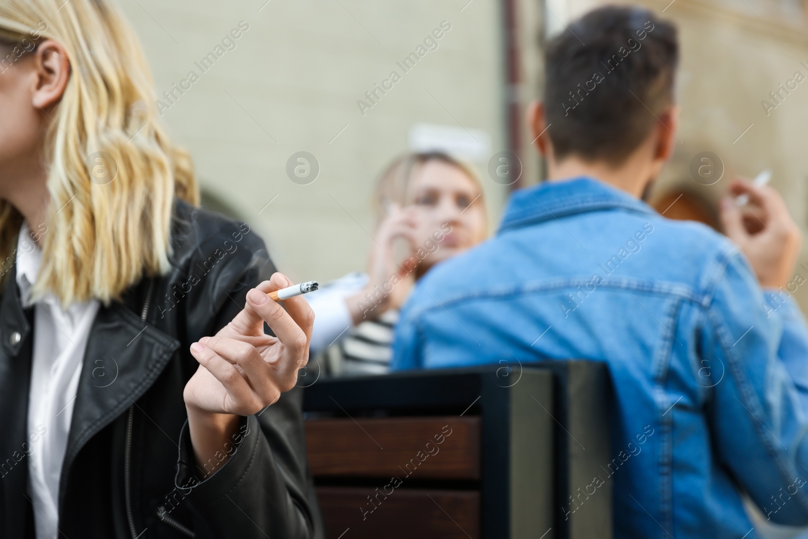 Photo of People smoking cigarettes at public place outdoors, closeup. Space for text