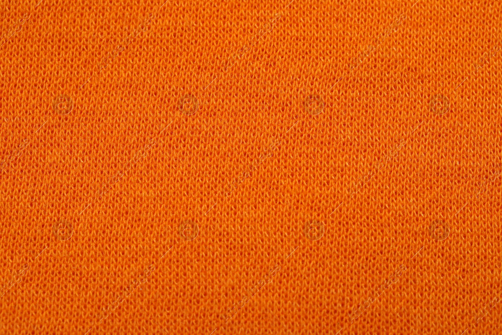 Photo of Texture of soft orange fabric as background, top view