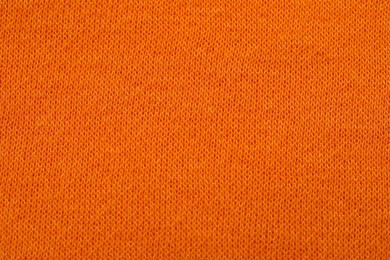 Texture of soft orange fabric as background, top view