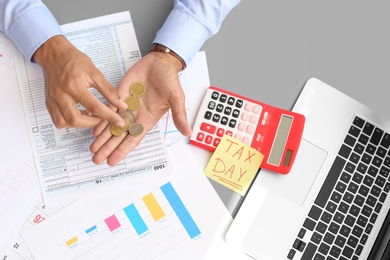 Photo of Tax accountant with money and documents at table