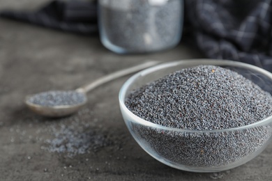 Poppy seeds in bowl on table. Space for text