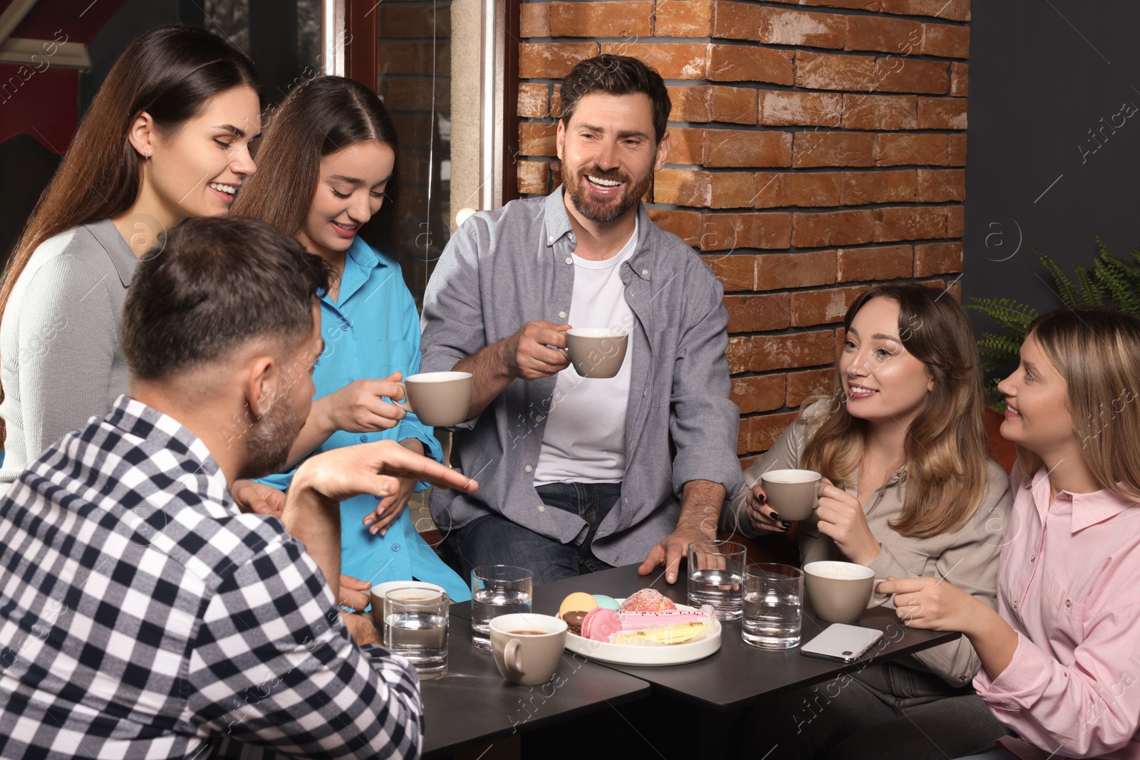 Photo of Friends with coffee spending time together in cafe