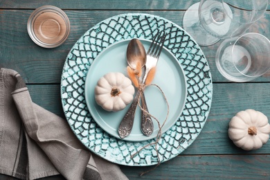 Autumn table setting with pumpkins on blue wooden background, flat lay