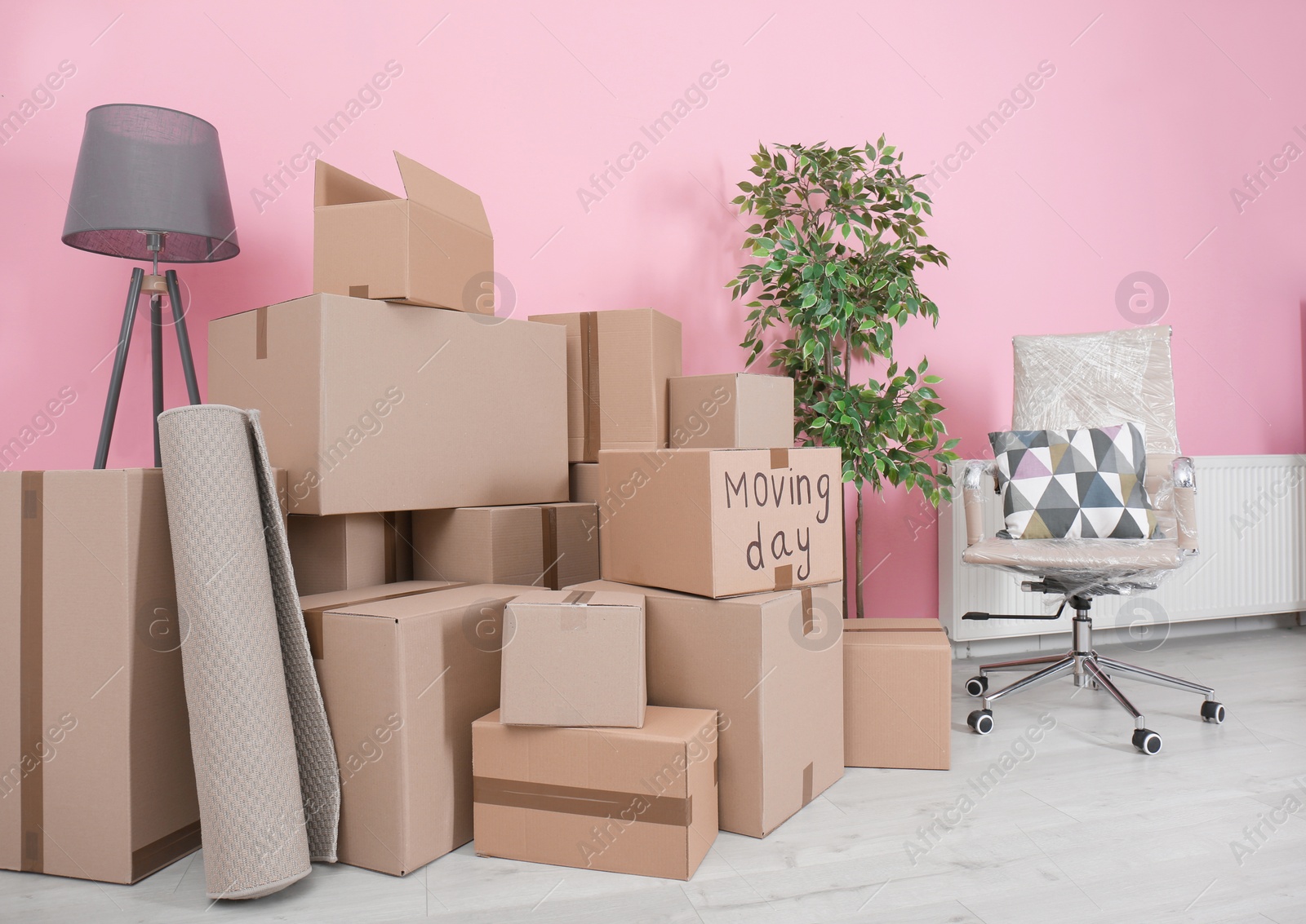 Photo of Cardboard boxes and household stuff in empty room. Moving day