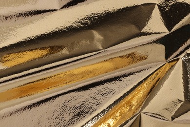 Photo of Edible gold leaf sheet as background, closeup