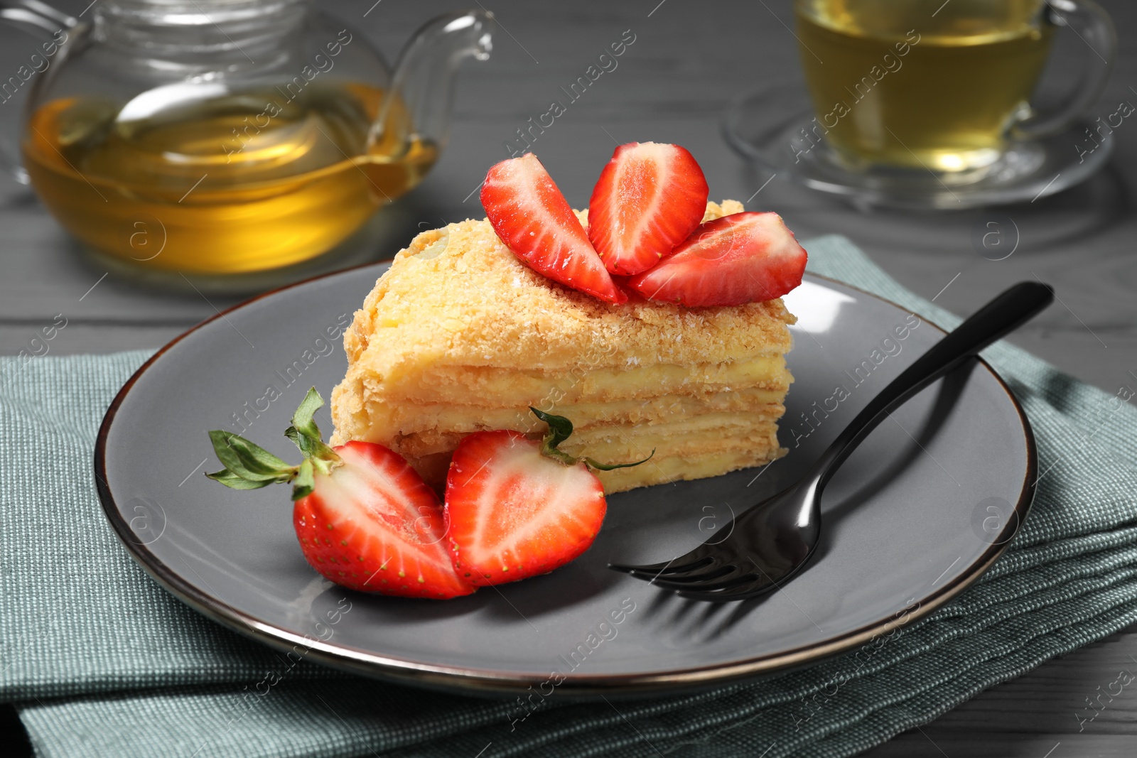 Photo of Piece of delicious Napoleon cake with strawberries on table, closeup