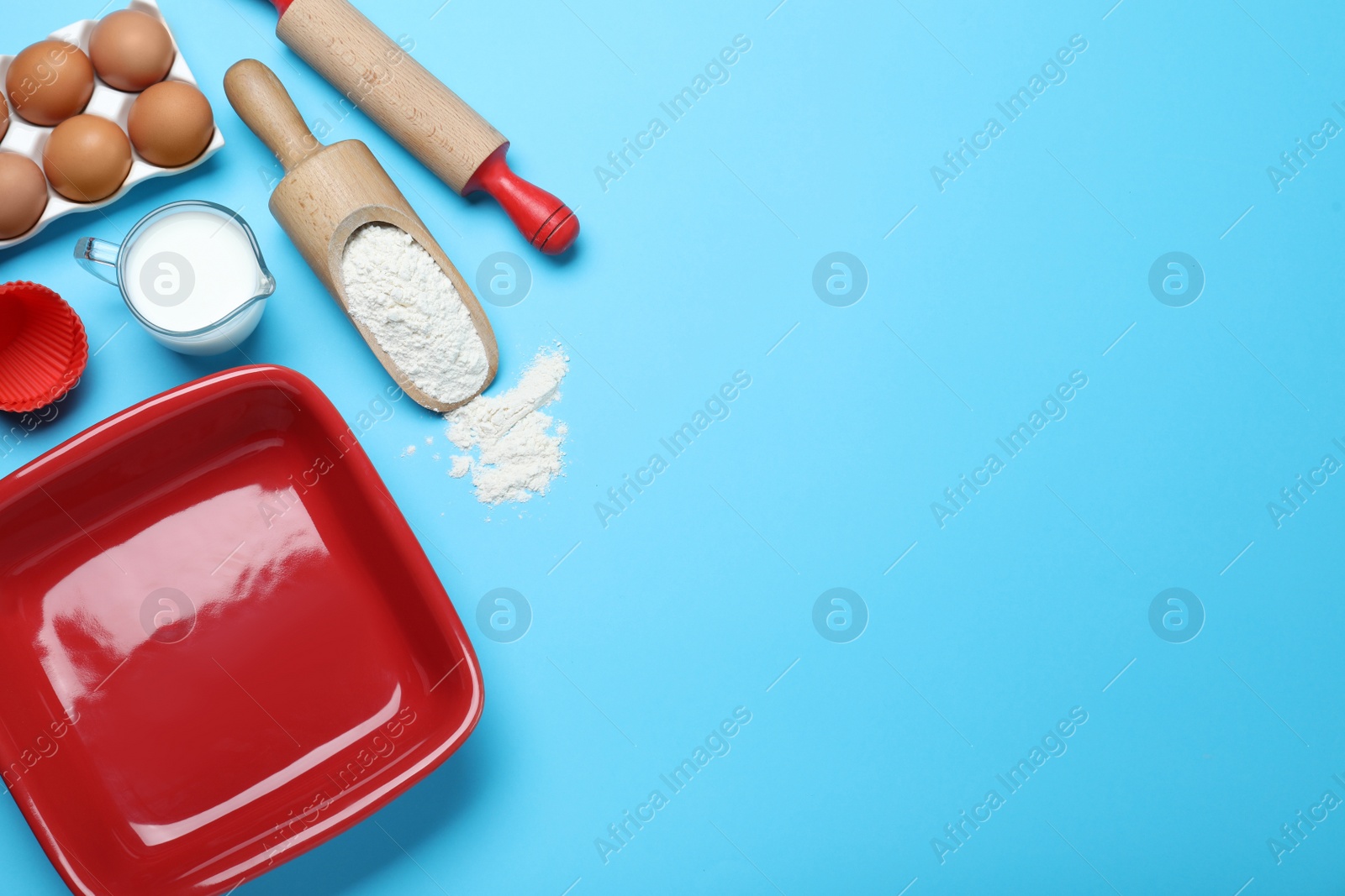 Photo of Cooking utensils and ingredients on light blue background, flat lay. Space for text