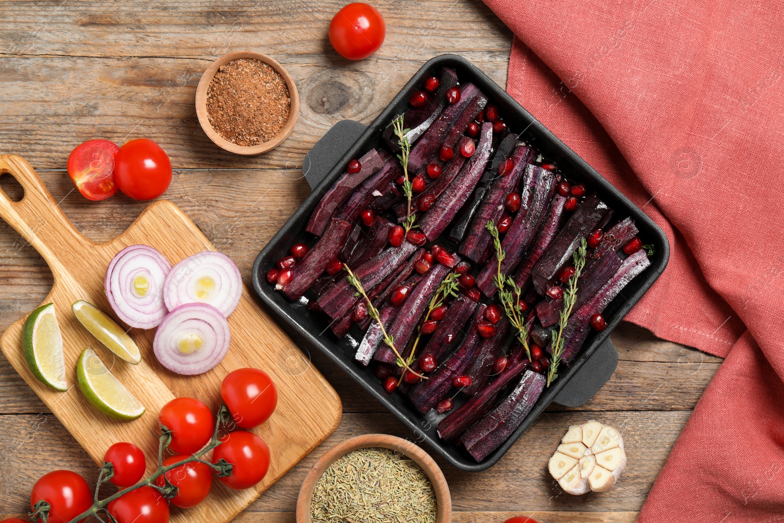 Photo of Flat lay composition with raw cut black carrot in baking dish on wooden table