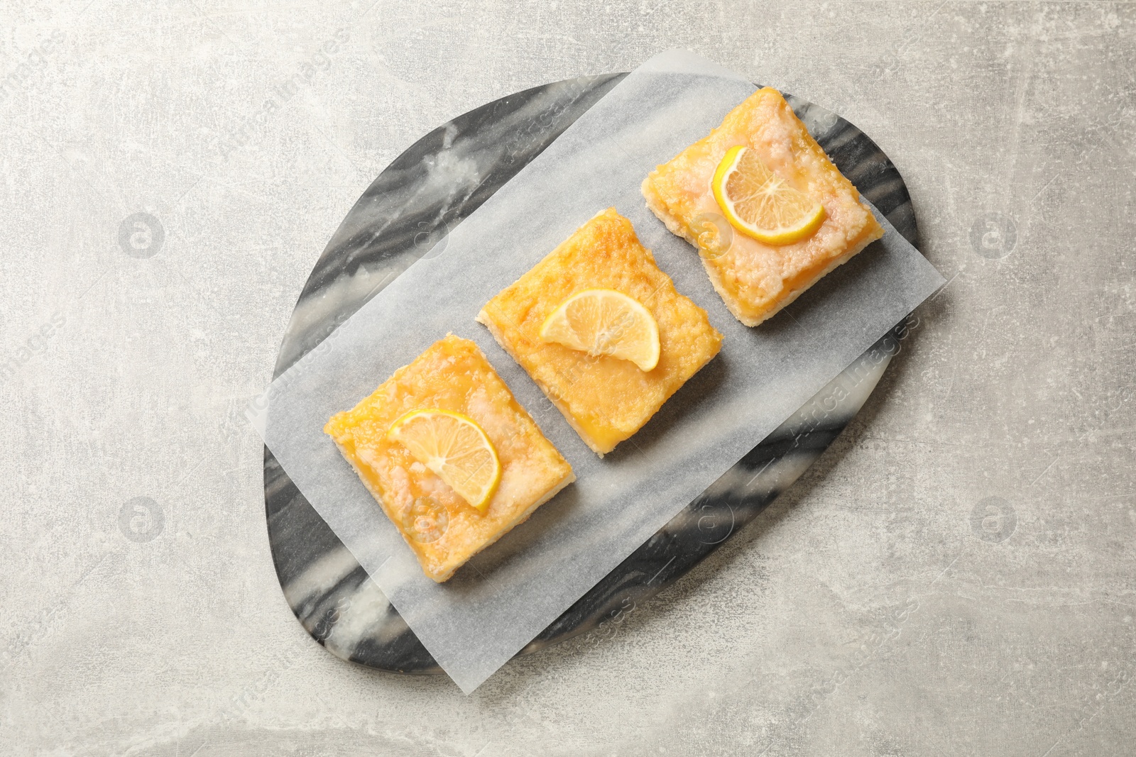 Photo of Tasty lemon bars on light grey table, top view