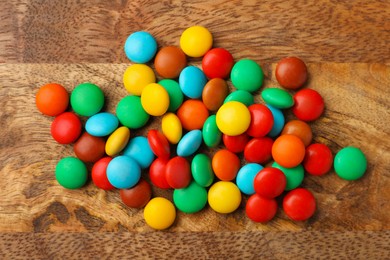 Photo of Tasty colorful candies on wooden table, flat lay