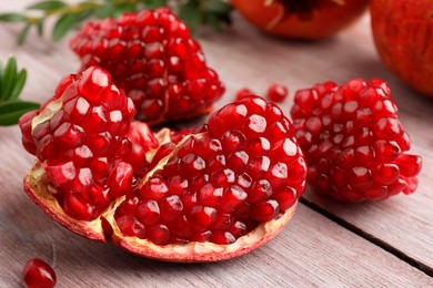 Cut fresh pomegranate on wooden table, closeup