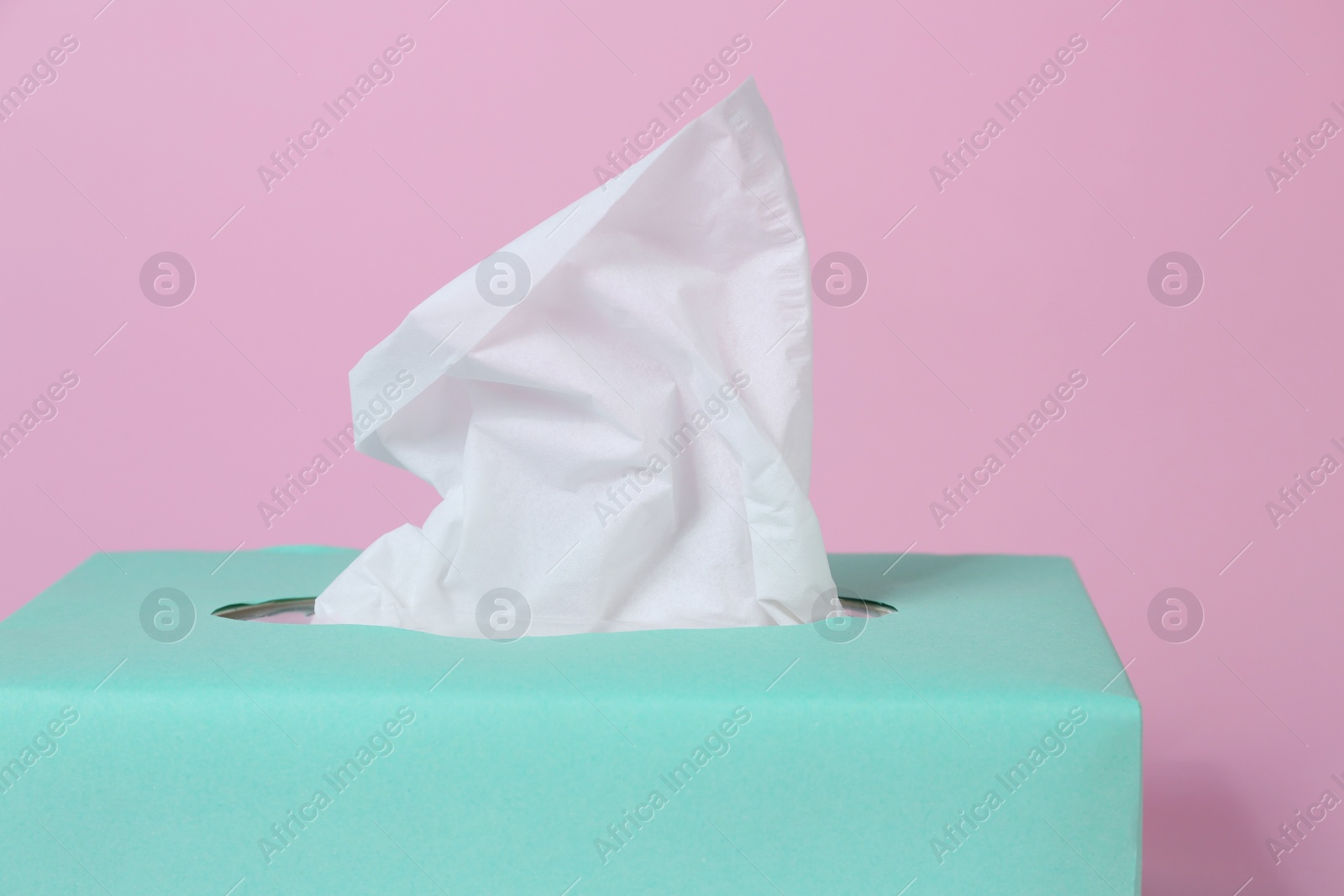 Photo of Box with paper tissues on pink background, closeup