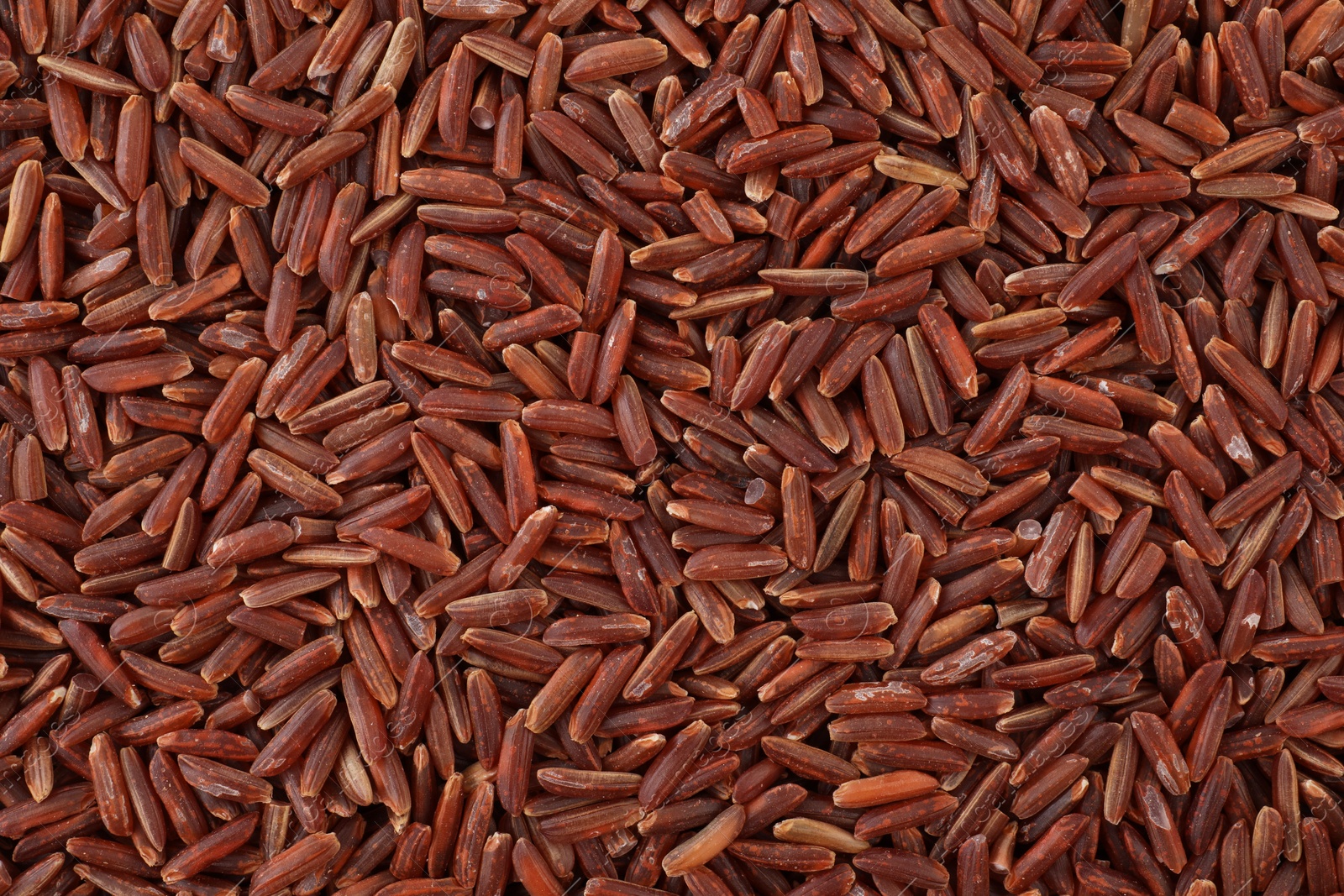 Photo of Raw red rice as background, top view