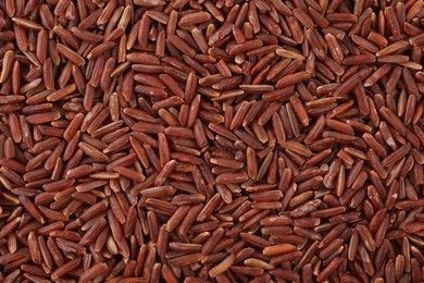 Raw red rice as background, top view