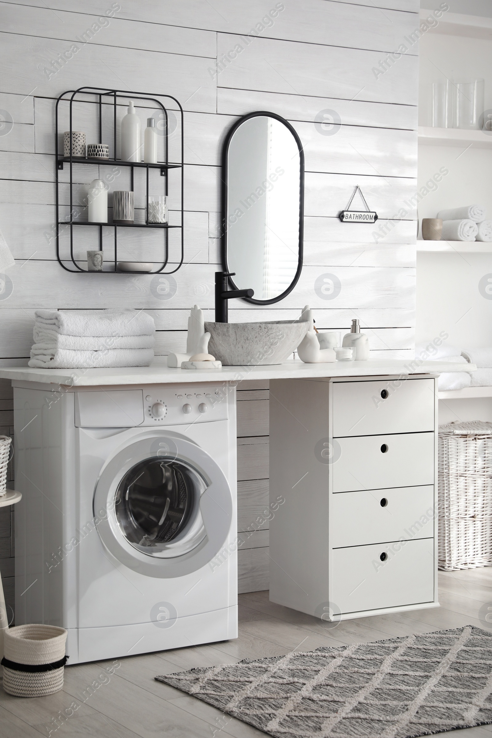 Photo of Stylish bathroom interior with modern washing machine