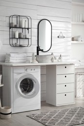 Stylish bathroom interior with modern washing machine