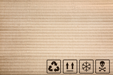 Image of Cardboard box with packaging symbols as background, closeup