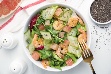 Delicious pomelo salad with shrimps served on white  table, flat lay