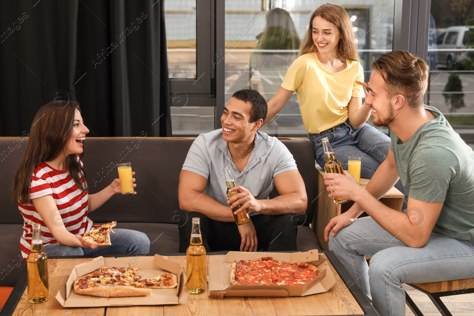 Photo of Group of friends having fun party with delicious pizza in cafe