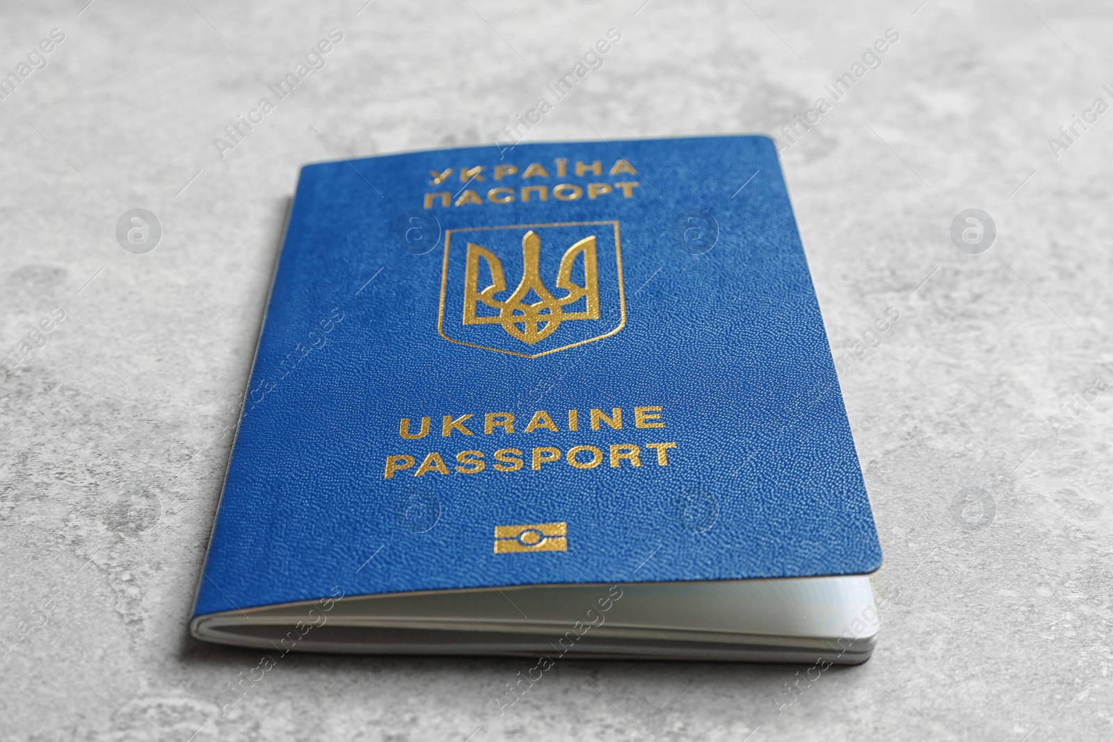 Photo of Ukrainian travel passport on grey background, closeup. International relationships