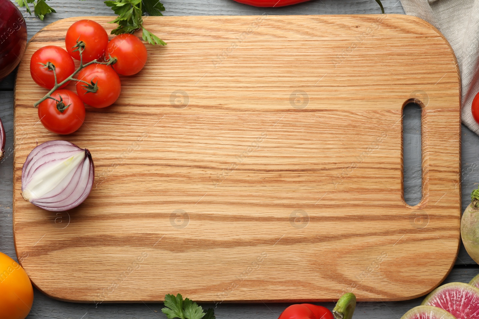 Photo of Flat lay composition with cutting board and products on grey wooden table