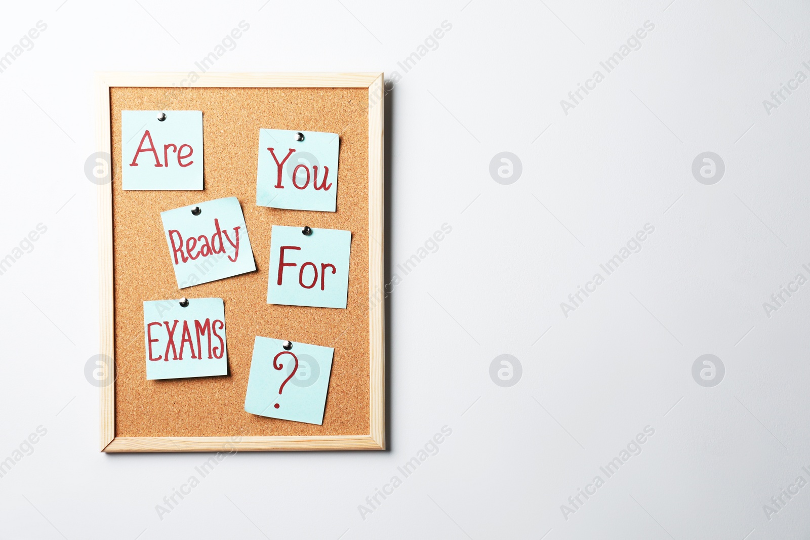 Photo of Cork board with question Are You Ready For Exams made of sticky notes on light grey wall. Space for text