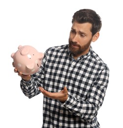 Man with ceramic piggy bank on white background