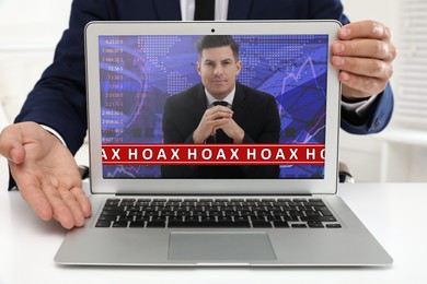 Image of Exposing hoax. Businessman demonstrating laptop with blogger indoors, closeup