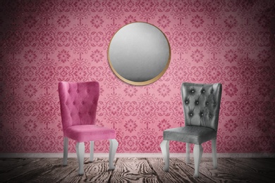 Chairs near wall with mirror and patterned wallpaper. Stylish room interior