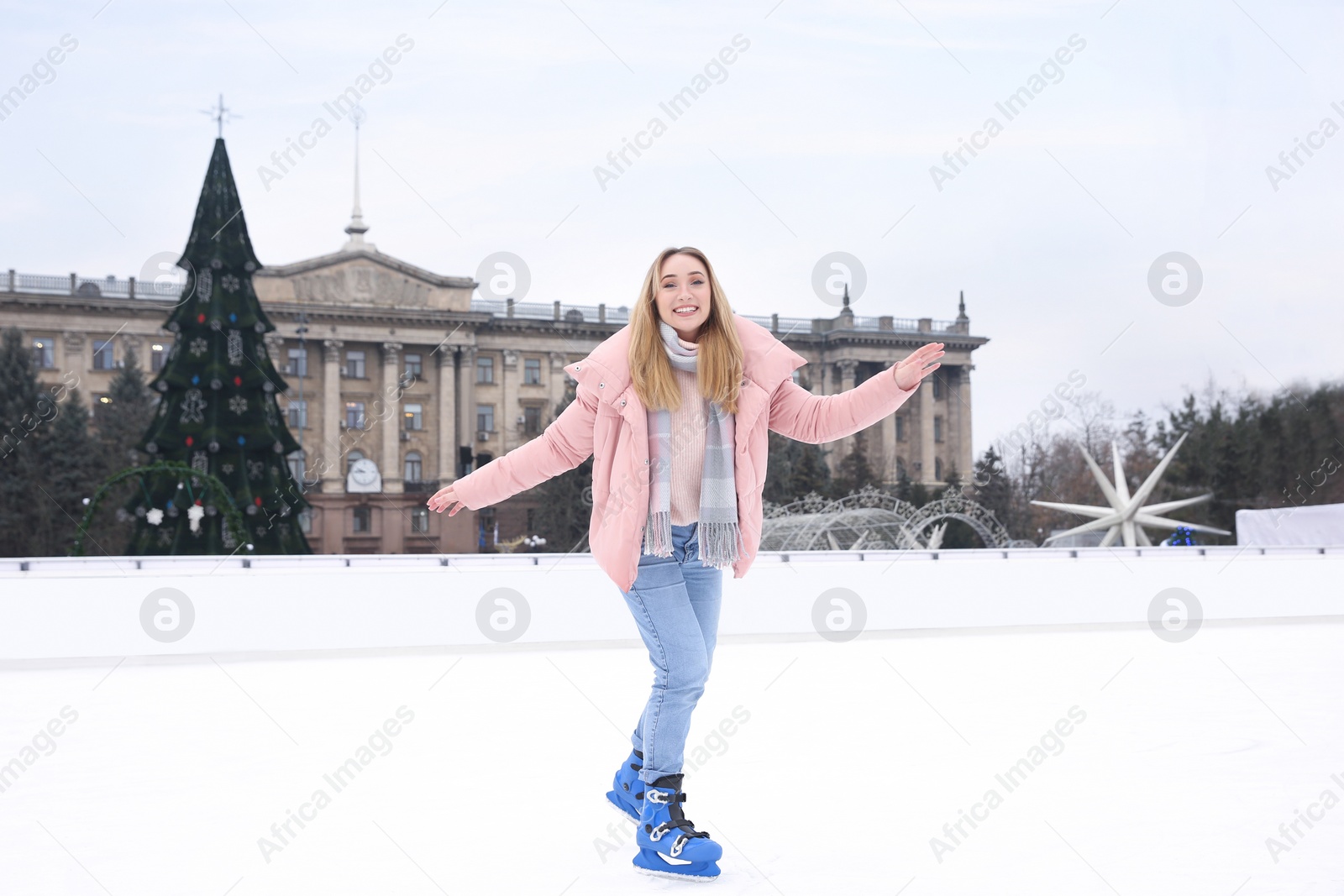 Image of Happy woman skating along ice rink outdoors