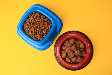 Wet and dry pet food in feeding bowls on yellow background, flat lay