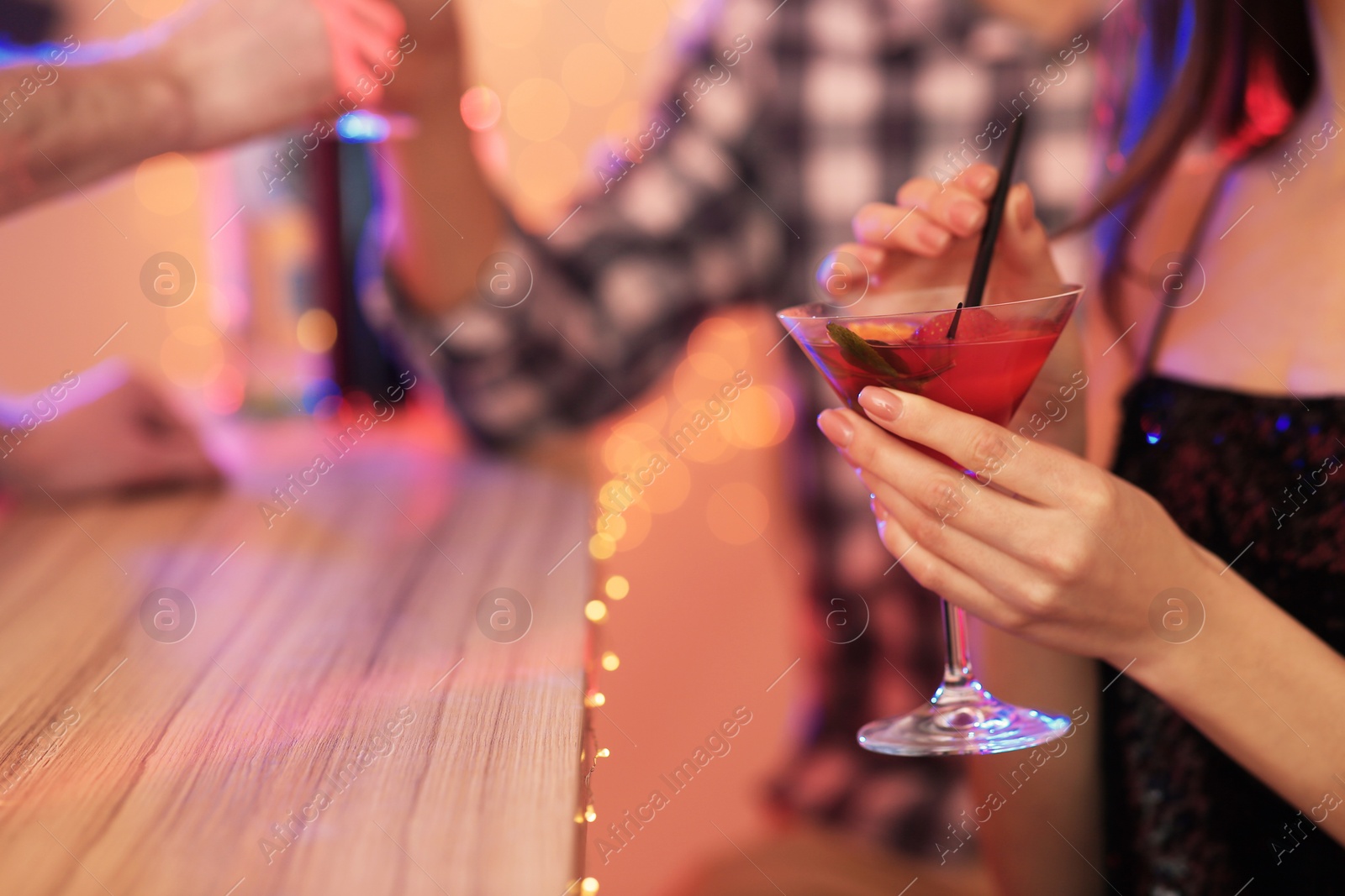 Photo of Young woman with glass of martini cocktail in bar, closeup. Space for text