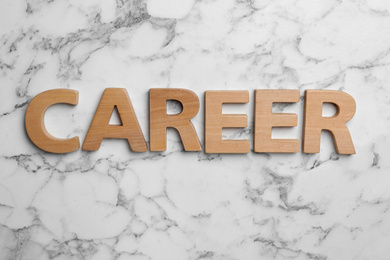 Photo of Word CAREER made with wooden letters on white marble background, flat lay