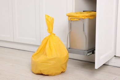 Photo of Plastic garbage bag and trash can indoors