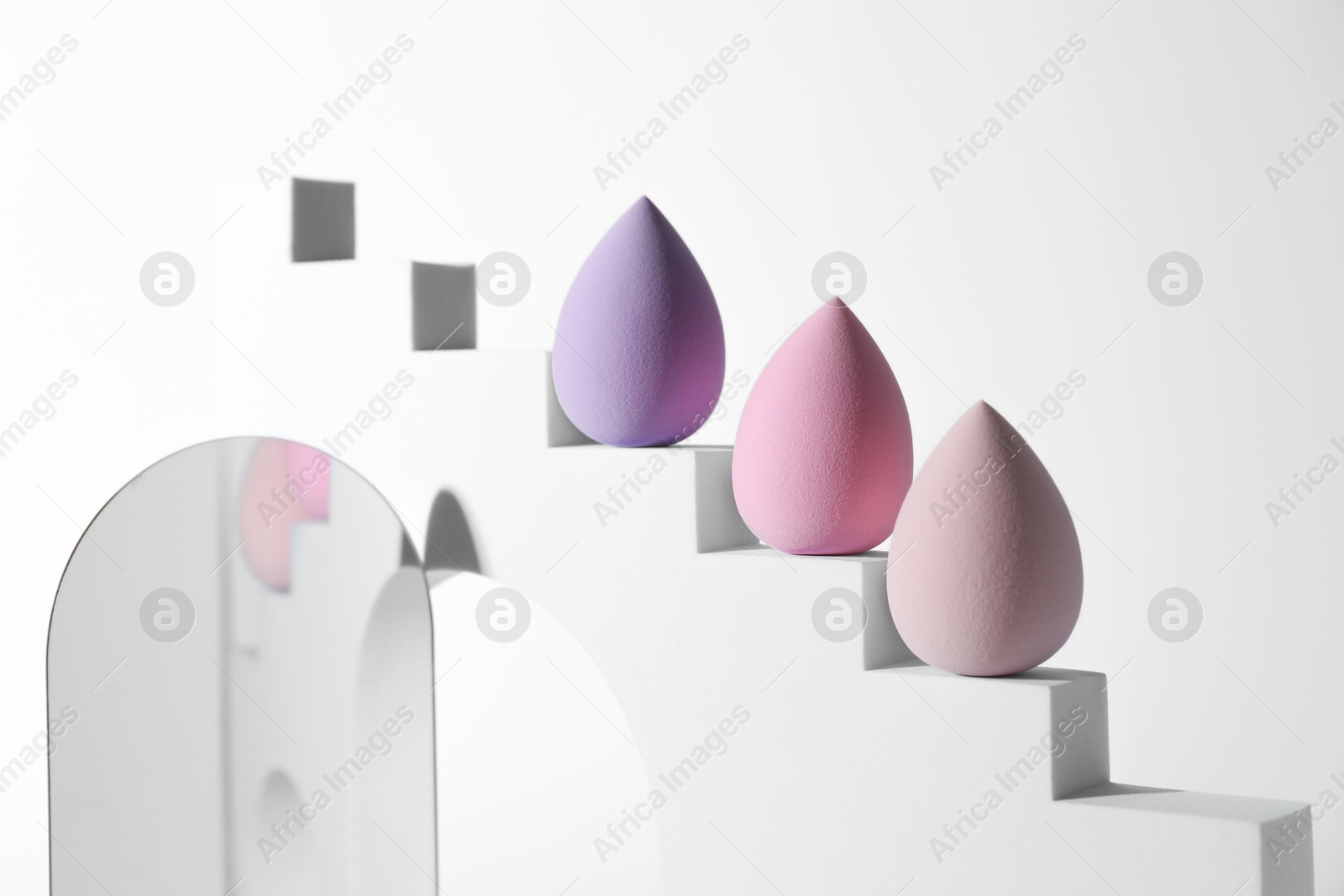 Photo of Stylish presentation of makeup sponges on white background