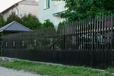 Beautiful black iron fence near pathway outdoors