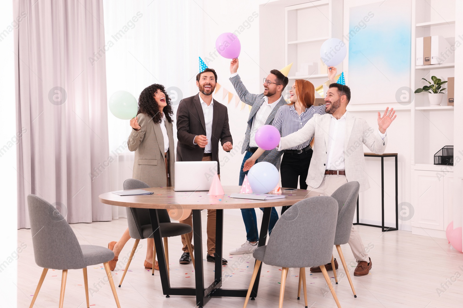 Photo of Coworkers having fun during office party indoors