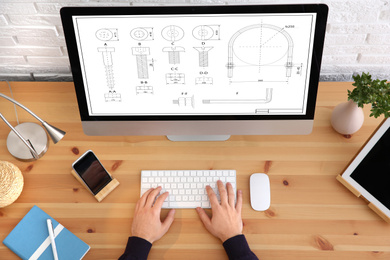 Image of Male engineer working with technical drawing on computer indoors, top view