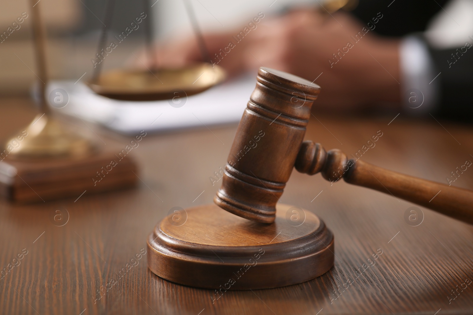 Photo of Law and justice. Closeup of judge working at wooden table, focus on gavel