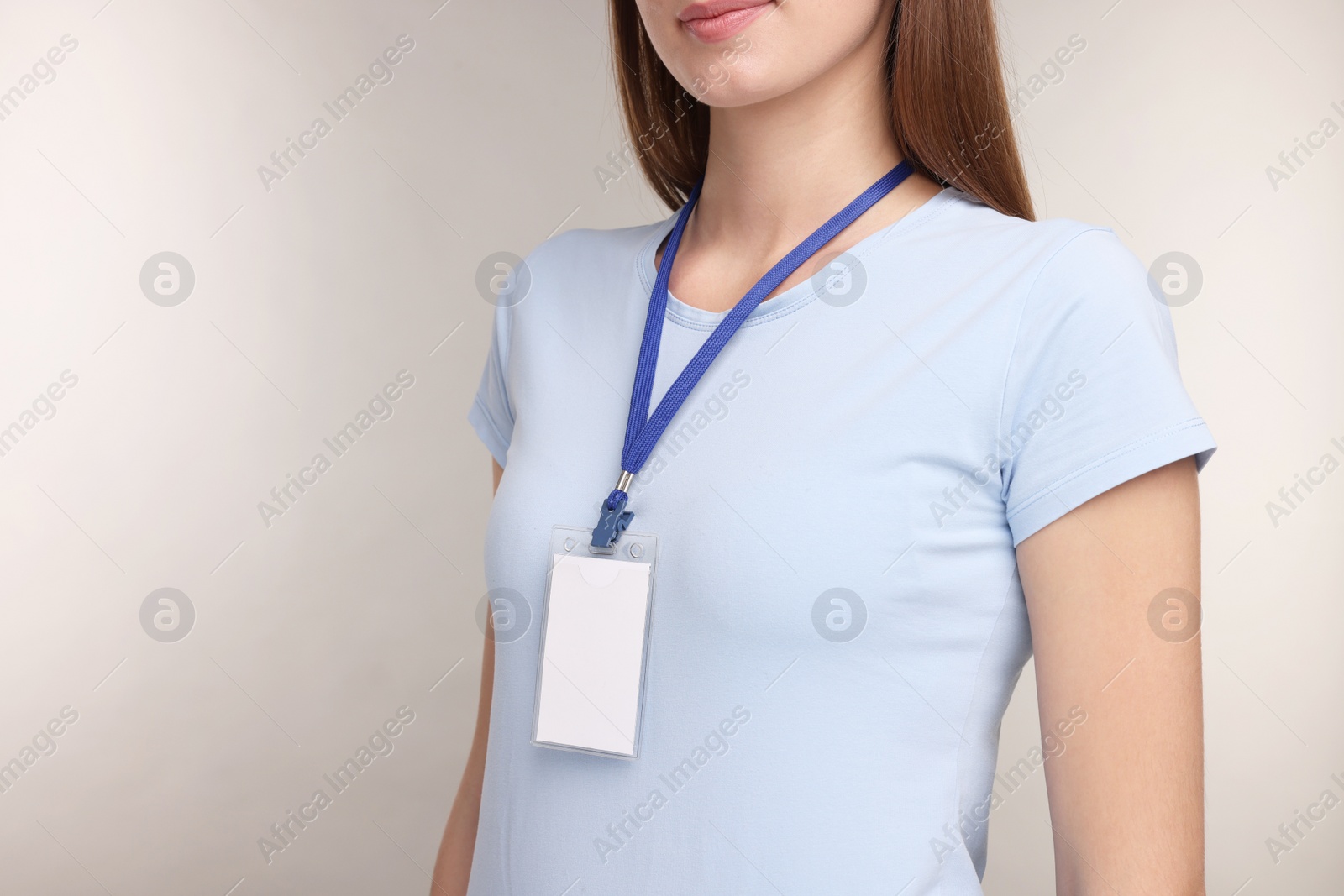 Photo of Woman with blank badge on grey background, closeup. Space for text