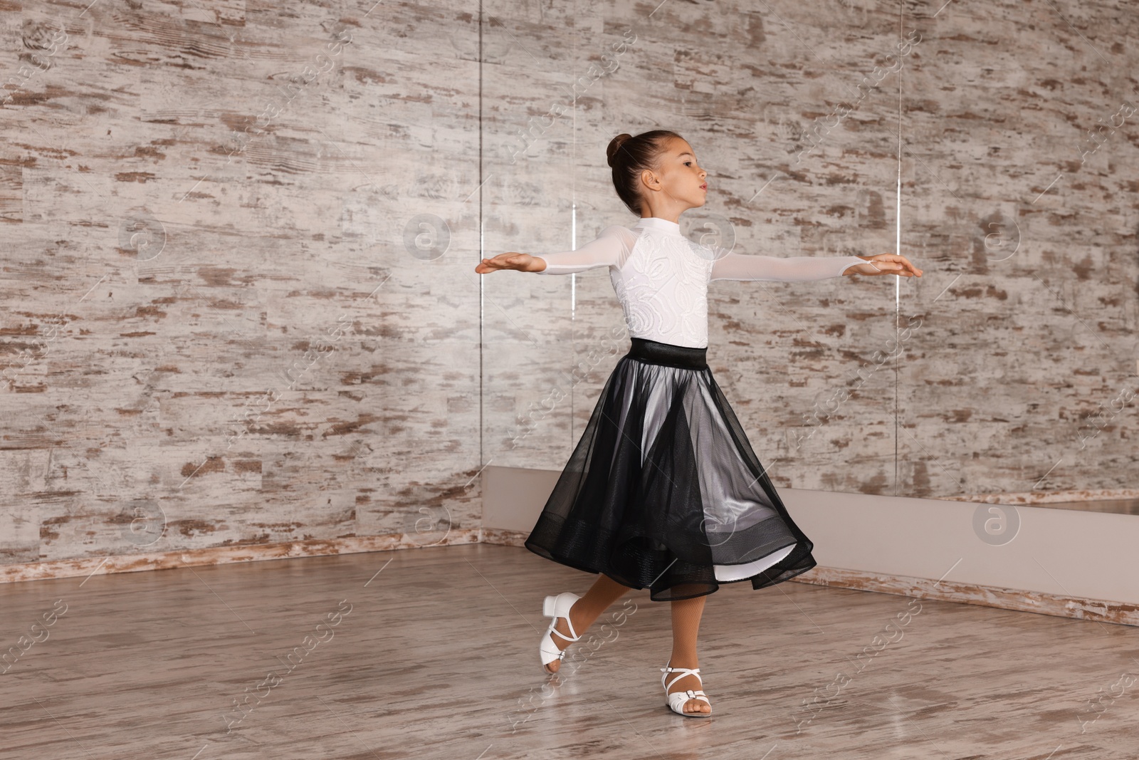 Photo of Adorable little girl dancing in studio, space for text