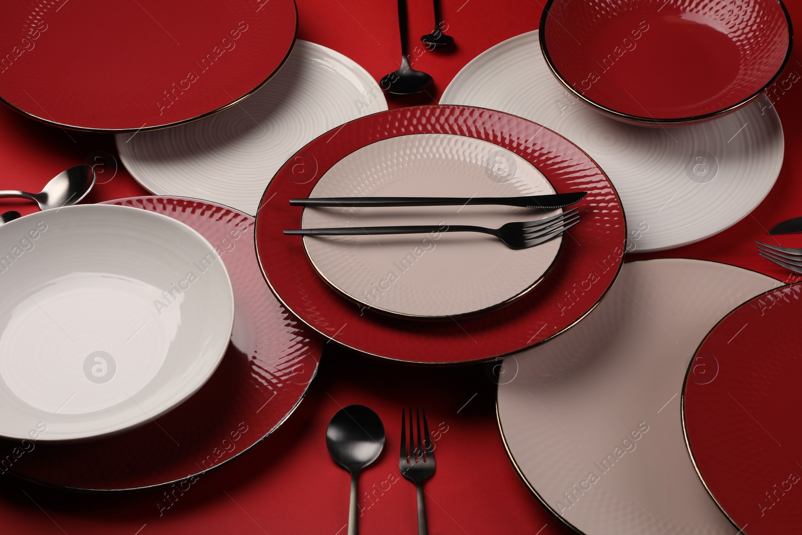 Photo of Stylish table setting with cutlery on red background