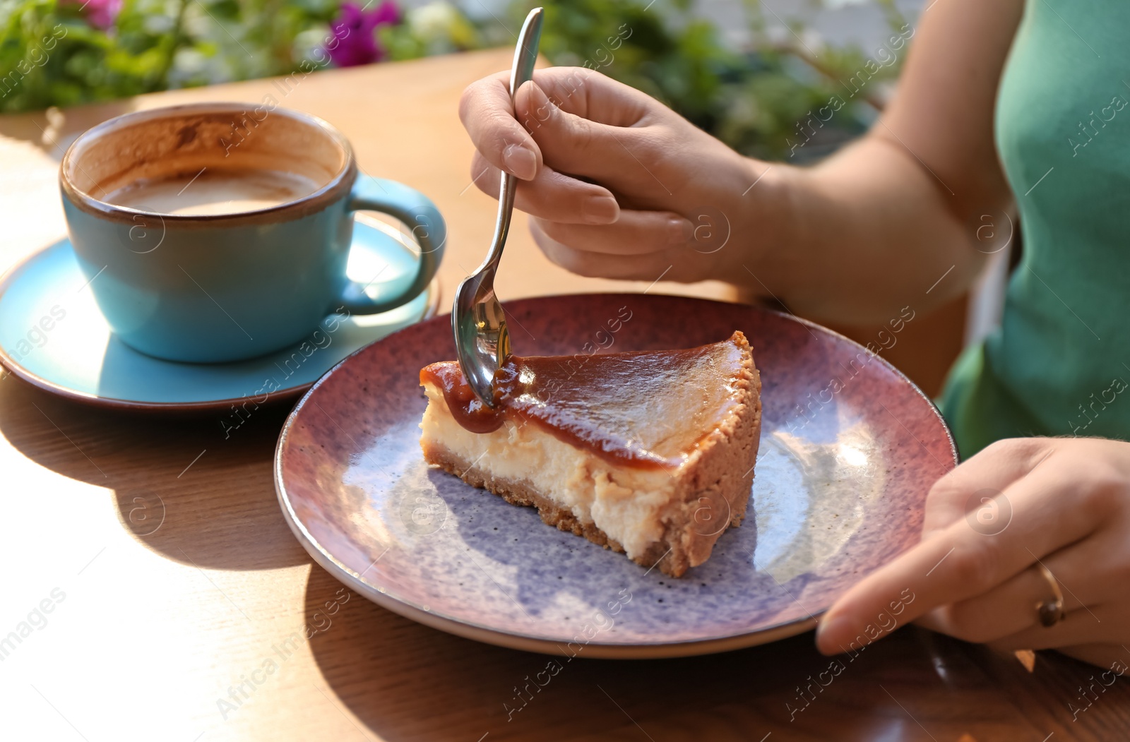 Photo of Woman eating slice of cake at table, closeup