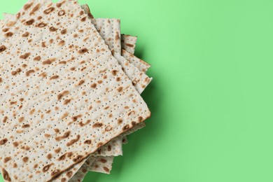 Photo of Stack of traditional matzos on green background, top view. Space for text