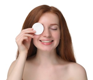 Photo of Smiling woman with freckles covering eye with cotton pad on white background