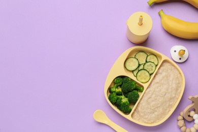 Photo of Healthy baby food in plate and accessories on violet background, flat lay. Space for text