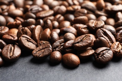 Roasted coffee beans on grey background, closeup