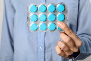 Photo of Woman holding blister with cough drops, closeup