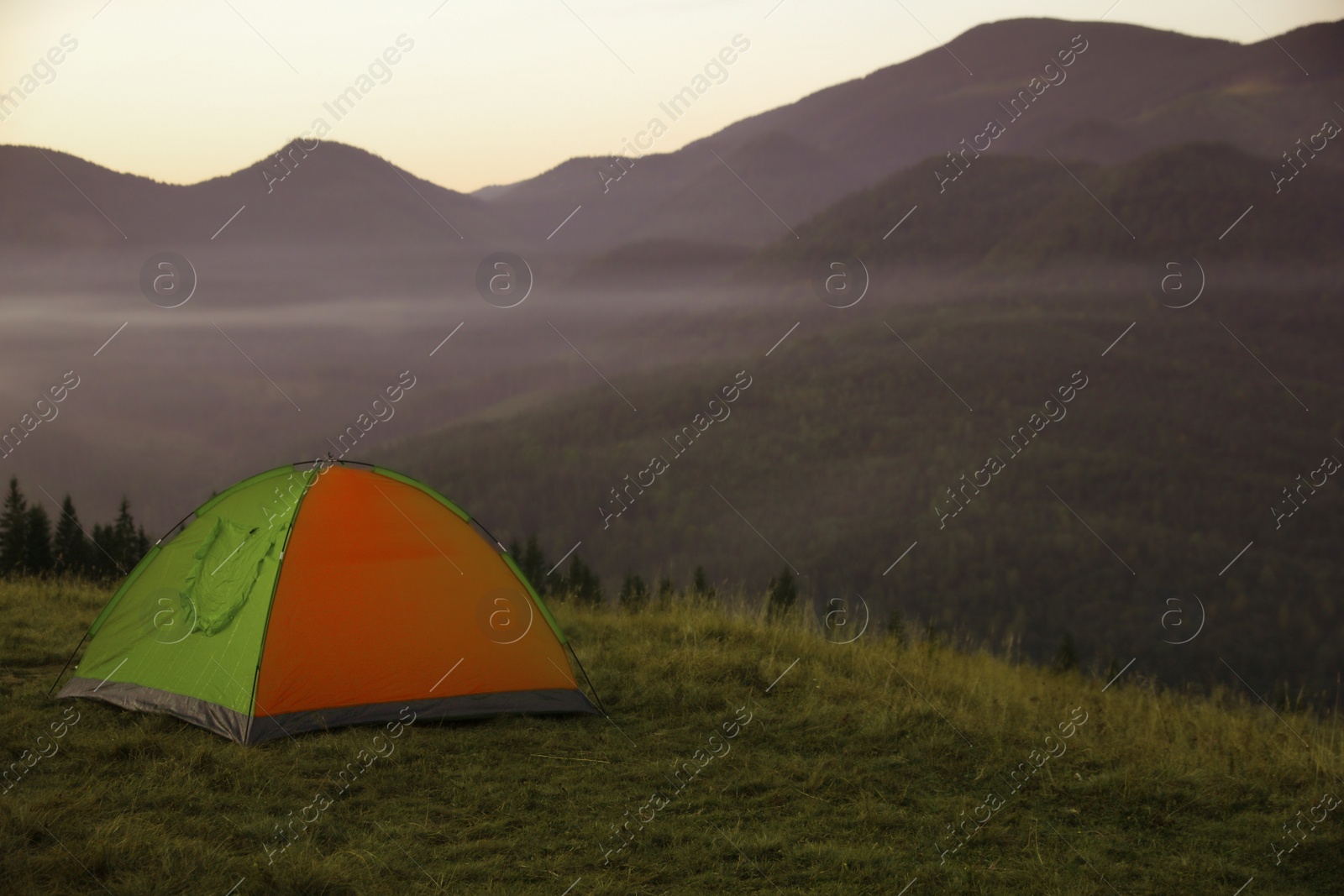 Photo of Camping tent on mountain slope in morning