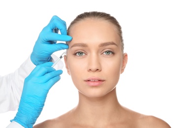 Photo of Young woman getting facial injection on white background. Cosmetic surgery concept